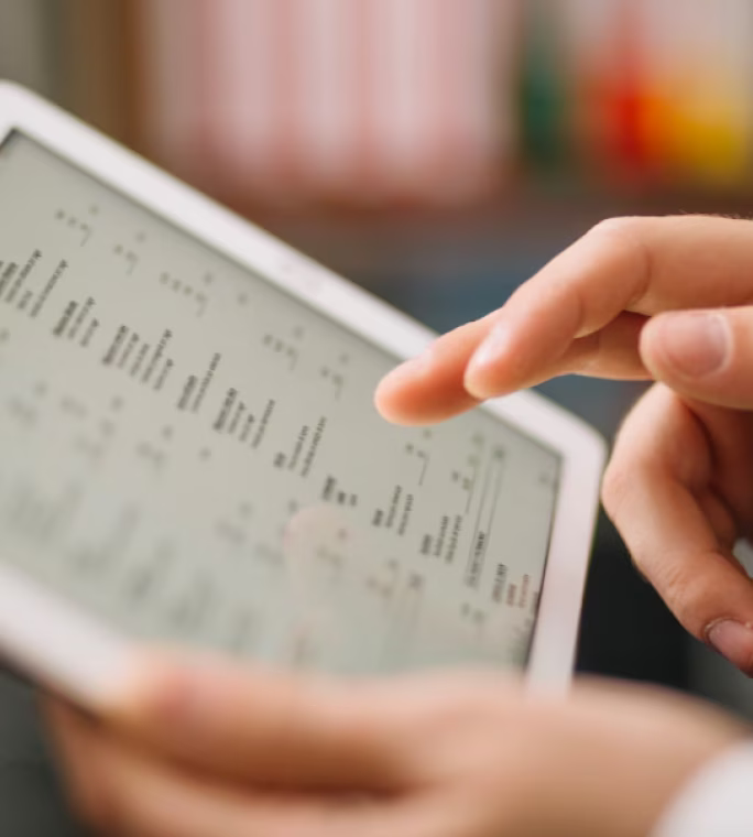Utilisateur consultant des données et indicateurs sur une tablette