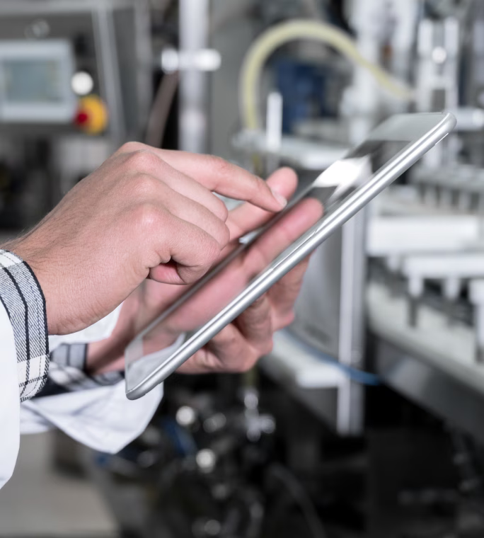 Gros plan sur une main utilisant l’écran d’une tablette tactile.