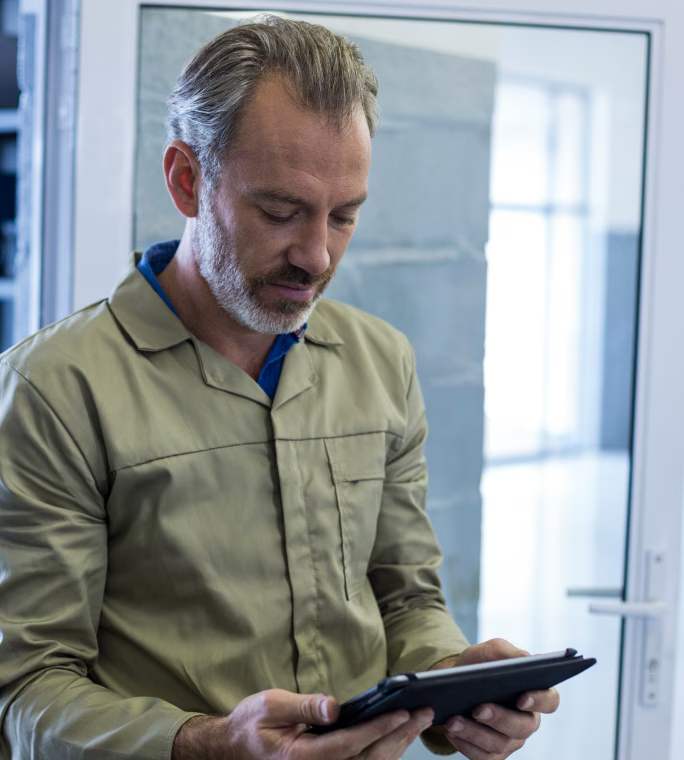 Opérateur consultant les données de production sur une tablette dans un environnement industriel