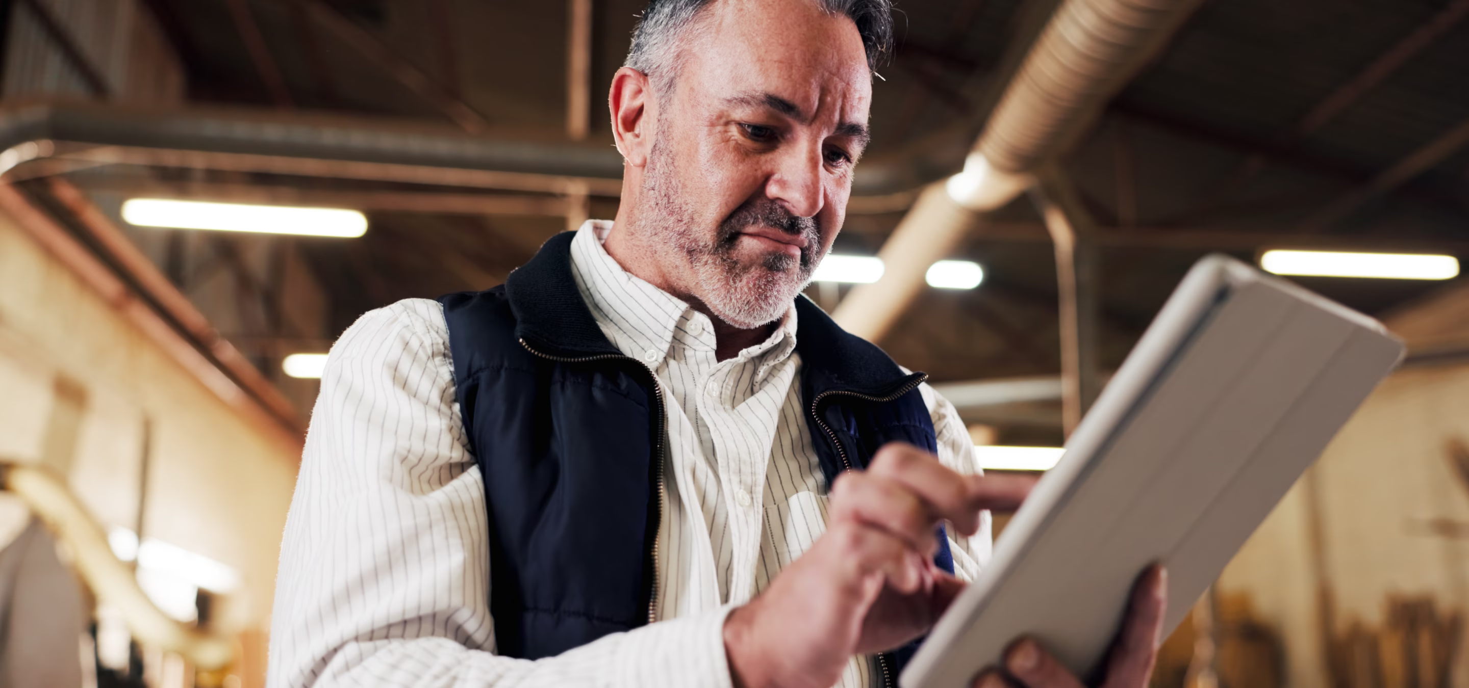qualite-atelier	Homme utilisant une tablette tactile dans un atelier.