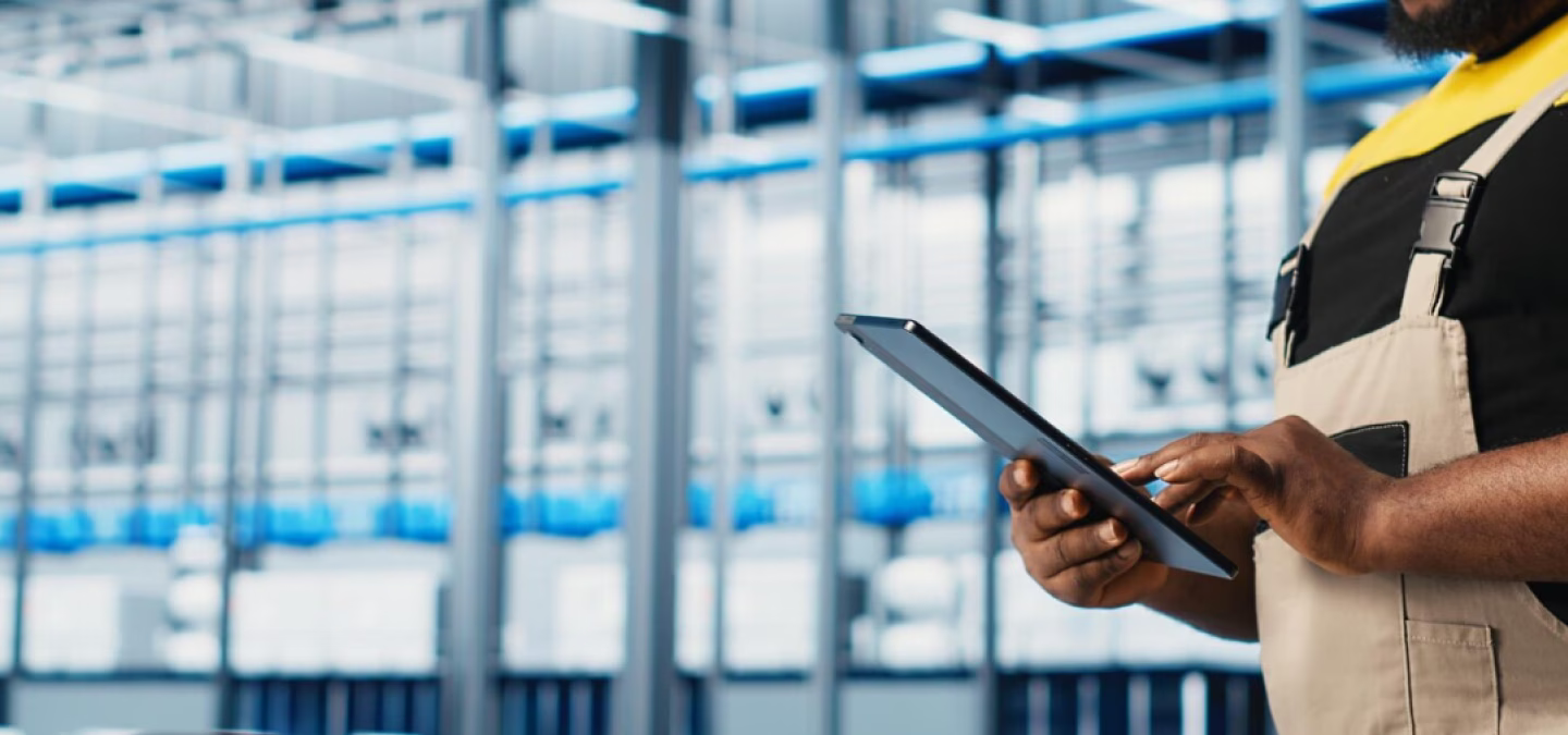 Responsable de production consultant des documents devant un ordinateur dans un atelier industriel