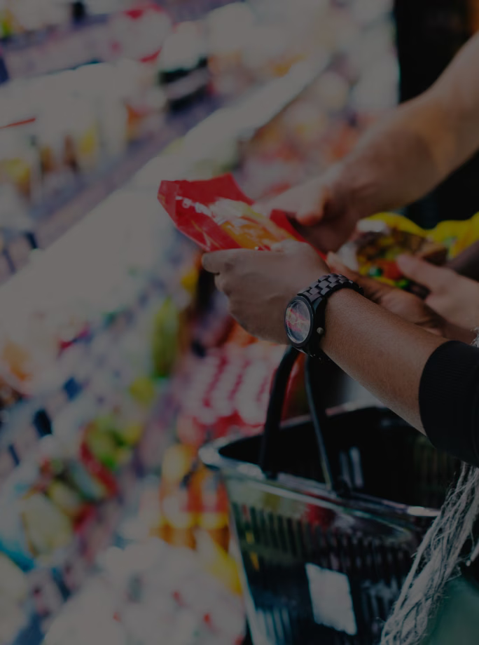 Cliente examinant l’emballage d’un produit dans un rayon de grande distribution