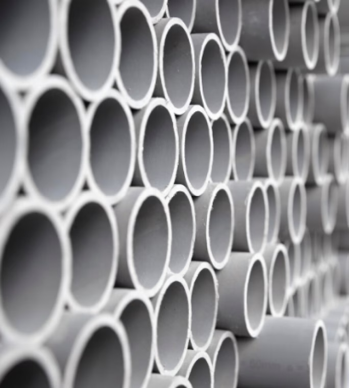 Empilement de profilés tubulaires en plastique blanc fabriqués par extrusion.