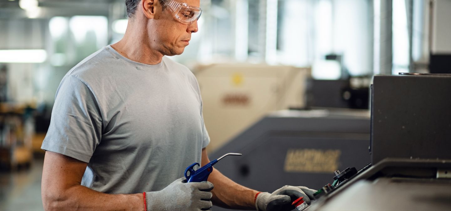 Opérateur utilisant le pupitre de commande d’une machine dans un atelier industriel